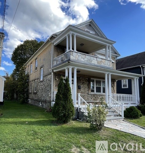 A two-story house with a balcony on the second floor.