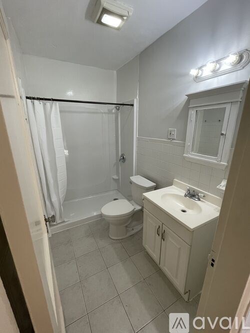 A bathroom with a toilet, sink, and shower.