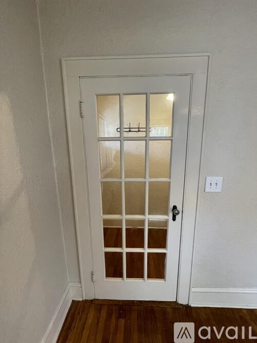 A white door with a glass panel and a black handle.