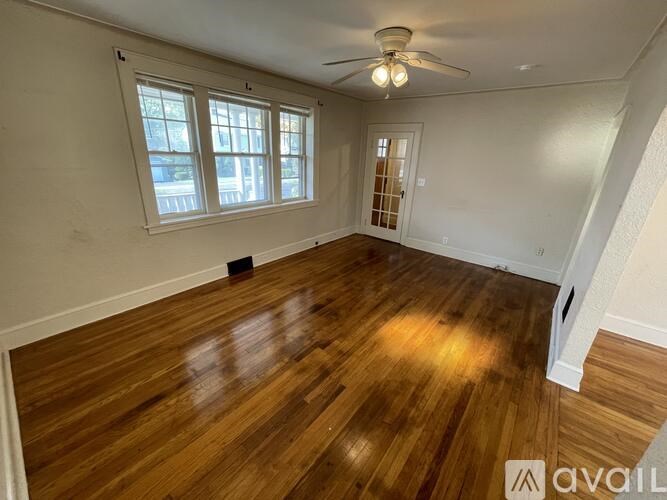A room with wooden flooring and a ceiling fan.