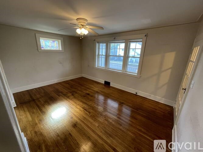 A room with wooden flooring and a ceiling fan.