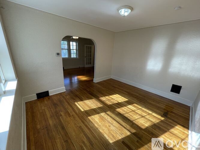 A room with wooden flooring and a window.
