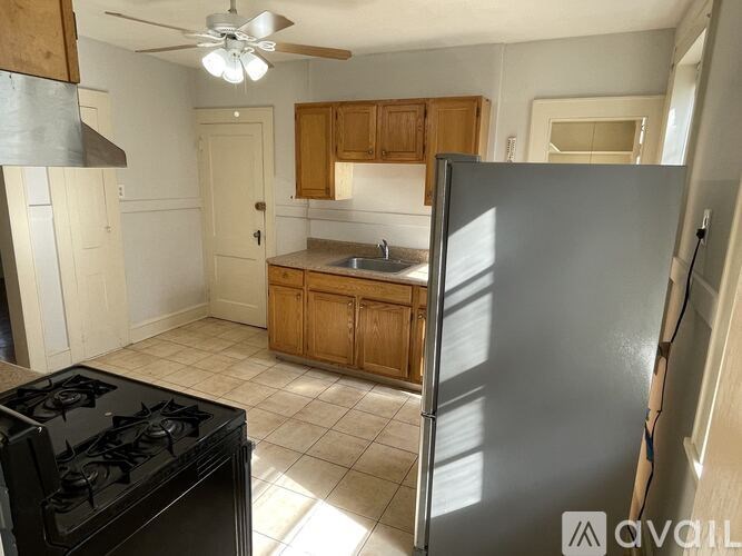 A kitchen with a black stove top oven and a black refrigerator.