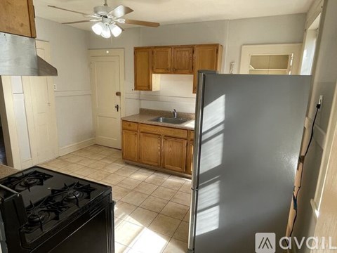 A kitchen with a black stove top oven and a black refrigerator.