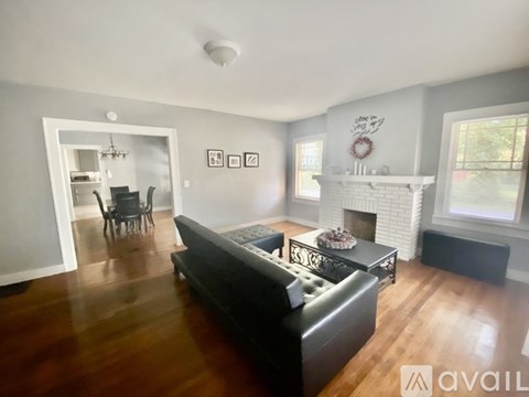 A living room with a black couch and a fireplace.
