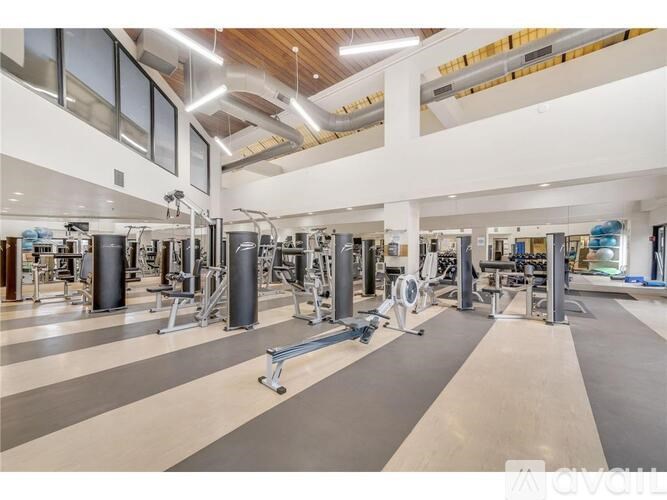 A gym with a variety of equipment including treadmills, weights, and exercise machines.