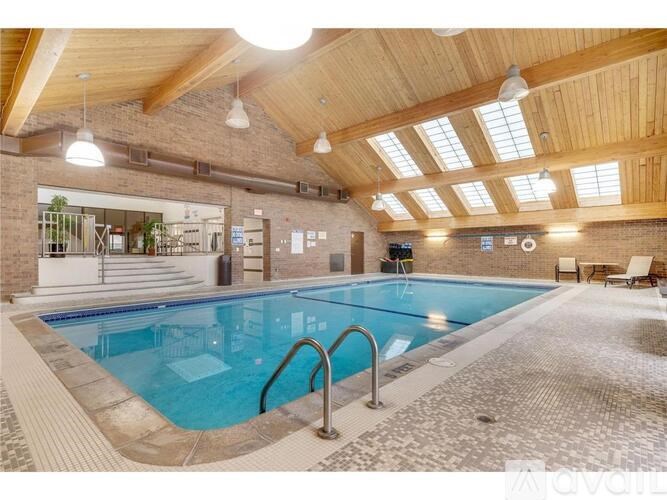 A large indoor swimming pool with a tiled floor and a wooden ceiling.