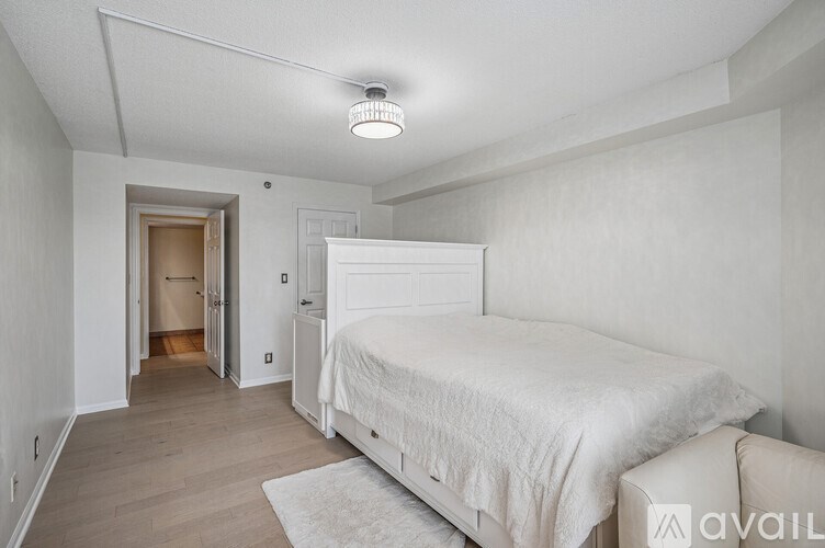 A bedroom with a large bed and a white couch.