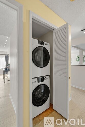 A washing machine is built into a wall in a room.