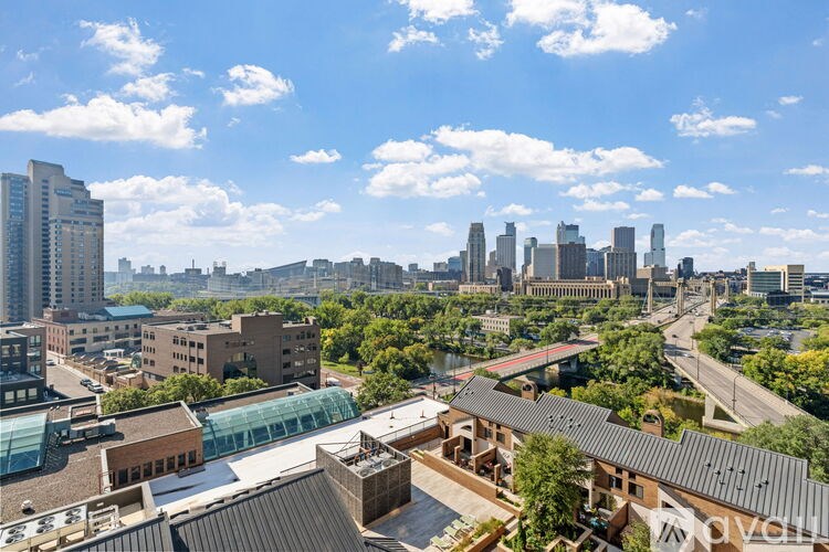 A cityscape with a mix of modern and older buildings, a clear sky, and a river running through the city.