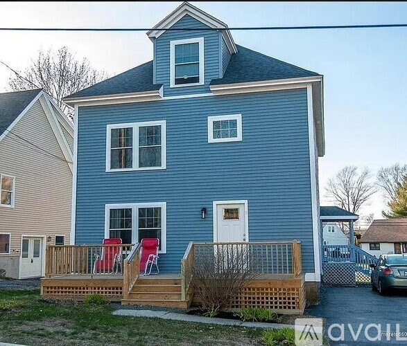 A blue house with a white door and windows.