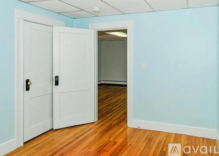 A room with two white doors and wooden flooring.