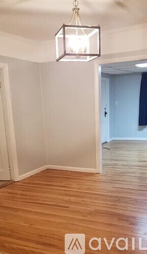 A room with wooden flooring and a hanging light fixture.