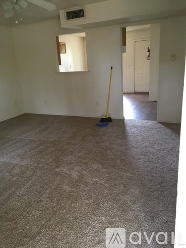 A room with a broom and a dustpan on the floor.