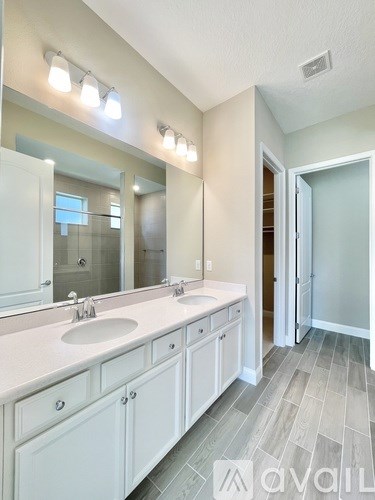 A bathroom with a double sink vanity and a large mirror.