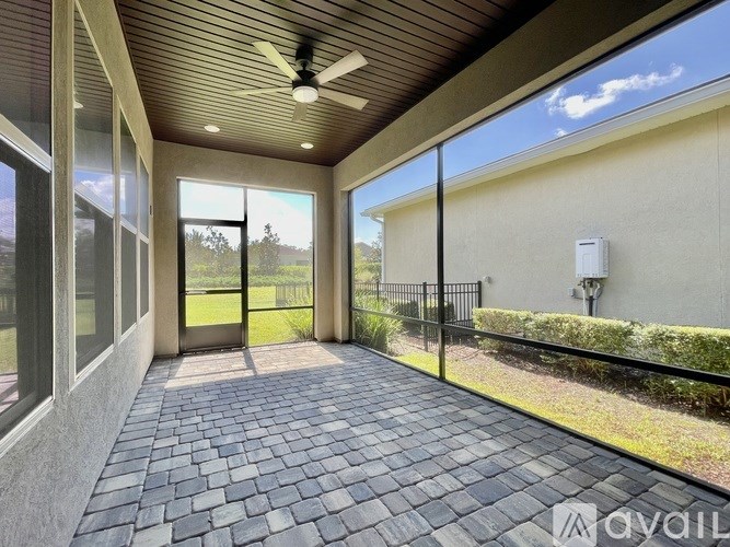 A patio with a ceiling fan and sliding glass doors.