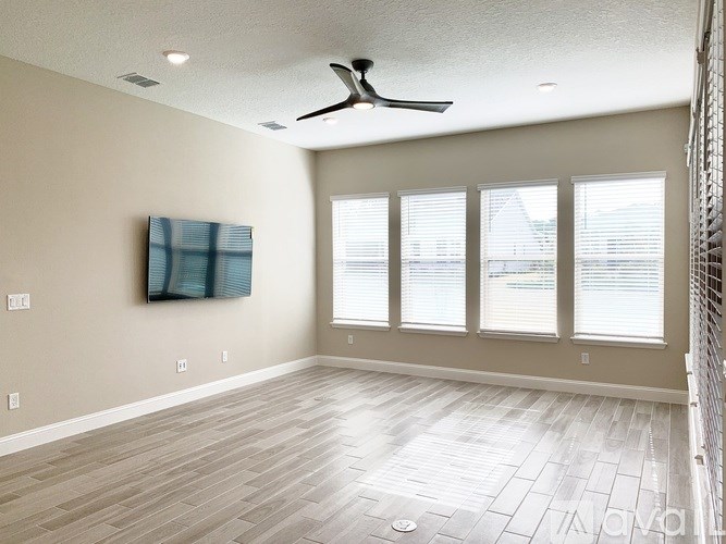 A room with a ceiling fan and a painting on the wall.