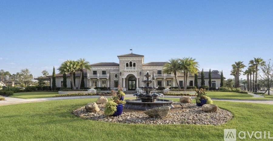 A large house with a fountain in front.