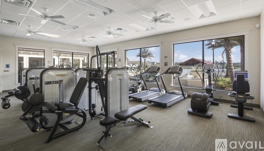 A gym with a variety of equipment including treadmills, weights, and exercise machines.