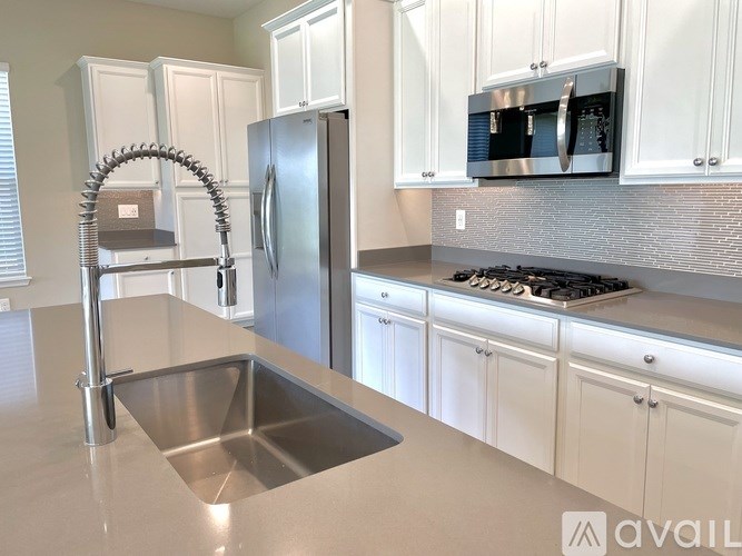 A kitchen with a stainless steel refrigerator and a sink.