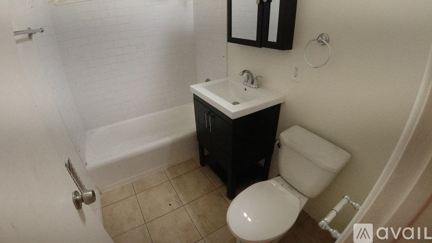 A bathroom with a toilet, sink, and mirror.