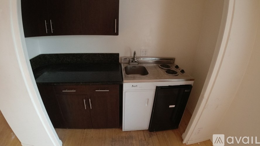 A small kitchen with a black countertop and white appliances.