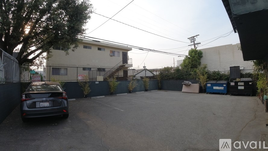 A car is parked in a lot with a building in the background.