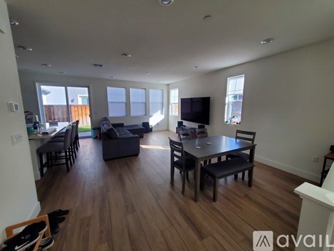 A living room with a black sofa, a black table and a television.