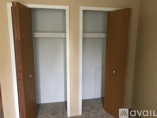 Two brown doors open to empty rooms.