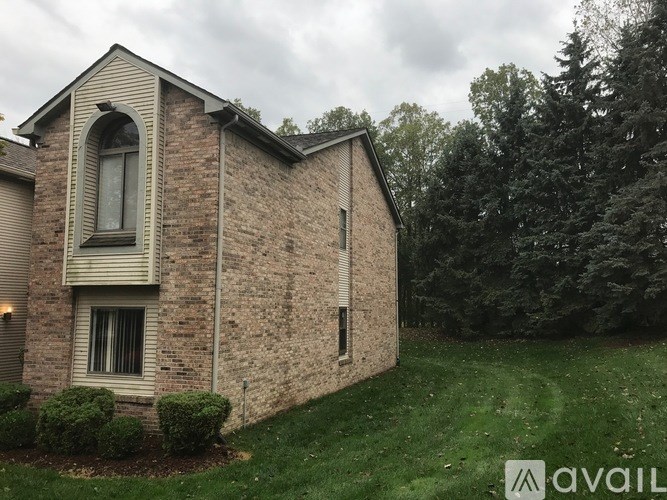 A house with a brick exterior and a large window is for sale.