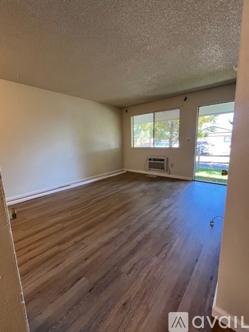 A room with wooden flooring and a window.