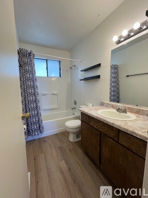 A bathroom with a toilet, sink, and mirror.