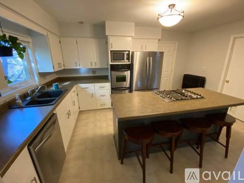 A kitchen with a table and chairs in the middle.