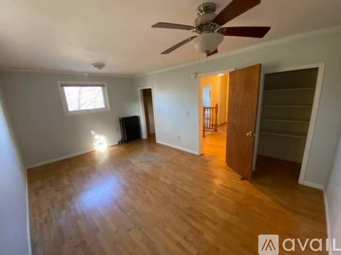 A room with wooden floors and a ceiling fan.