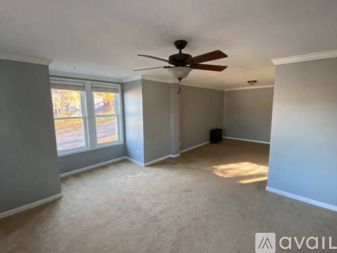 A room with a ceiling fan and a window.