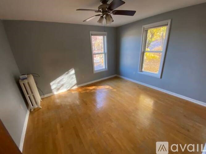A room with wooden floors and two windows.
