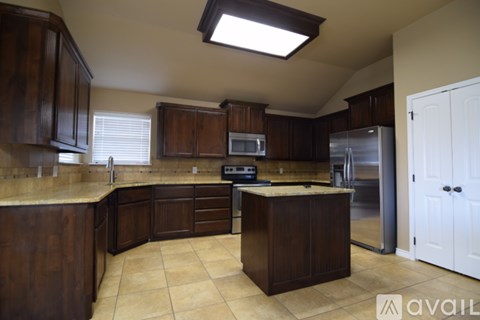 A kitchen with brown cabinets and a white door.