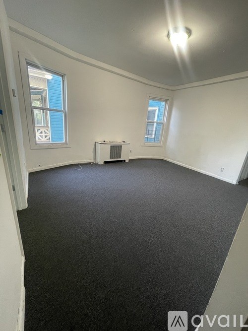 A room with a carpeted floor and a window.