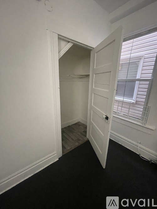 A white door is open to a room with a window.