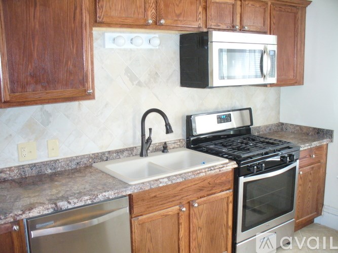 A kitchen with a black microwave above the stove.