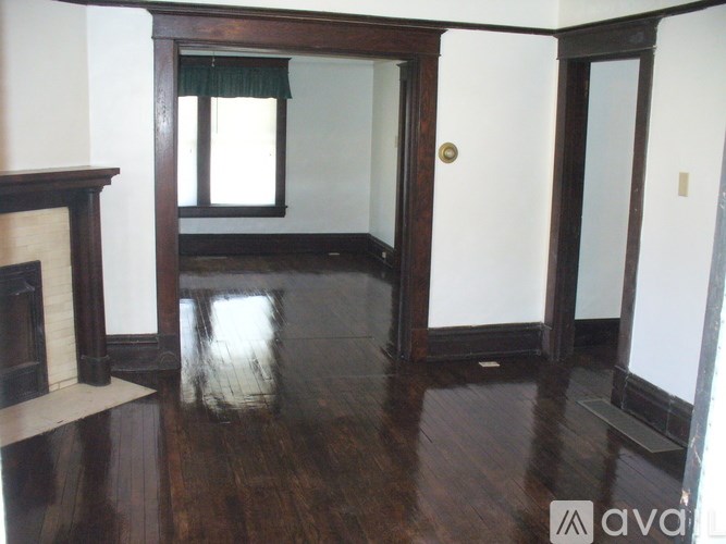 A room with a wooden floor and a fireplace.