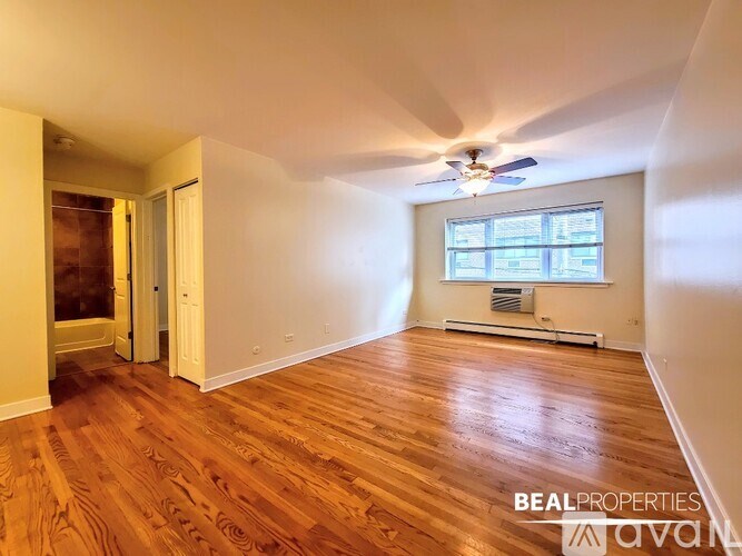 A room with wooden floors and a ceiling fan.
