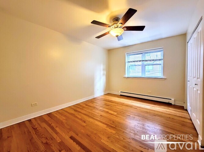 A room with a ceiling fan and a window with an air conditioner unit underneath it.