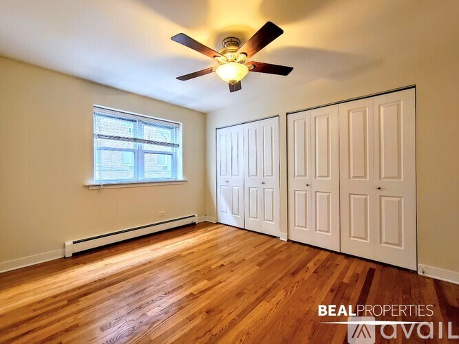 A room with a ceiling fan and wooden floors.