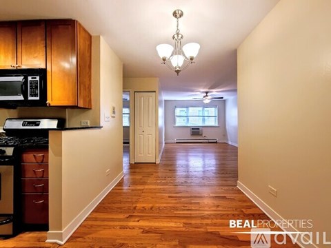 A kitchen with wooden cabinets and a chandelier.