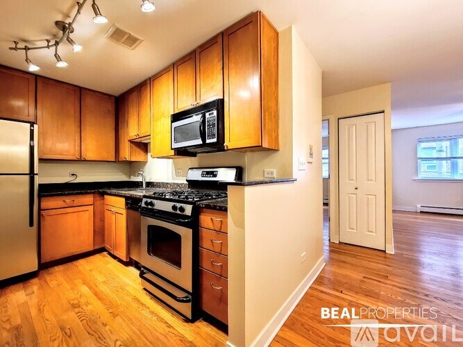A kitchen with wooden cabinets and a stove top oven.