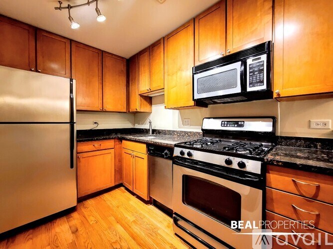 A kitchen with wooden cabinets and a stainless steel refrigerator.