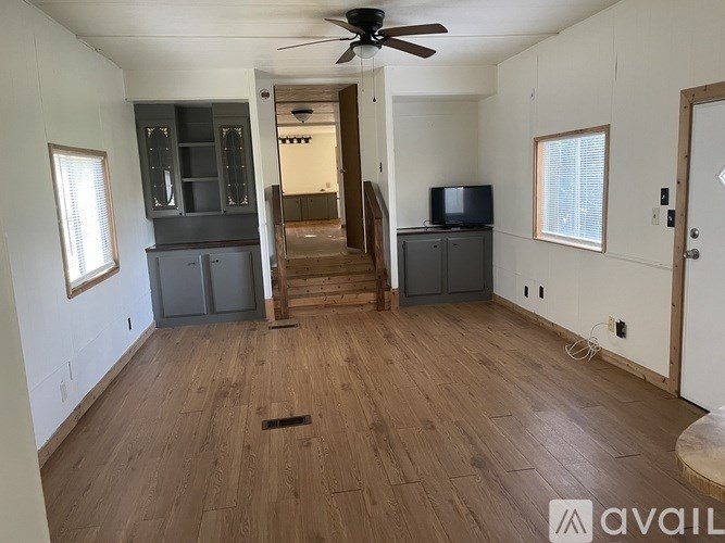 A room with wooden floors and a ceiling fan.