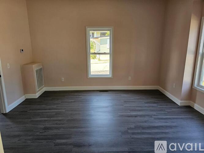 A room with a window and a radiator on the wall.