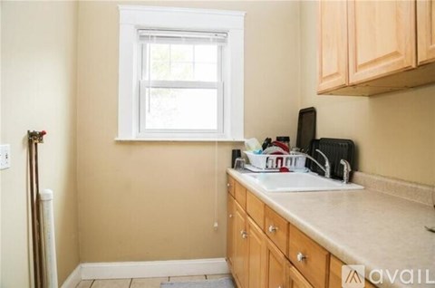 A kitchen with wooden cabinets and a window.